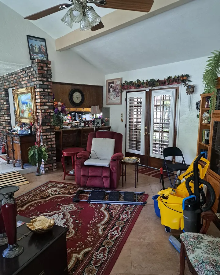 Living room during an Awesome Cleaning job, with a yellow mop bucket in place
