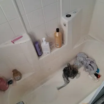 Bathtub with staining and cleaning cloths in it before cleaning