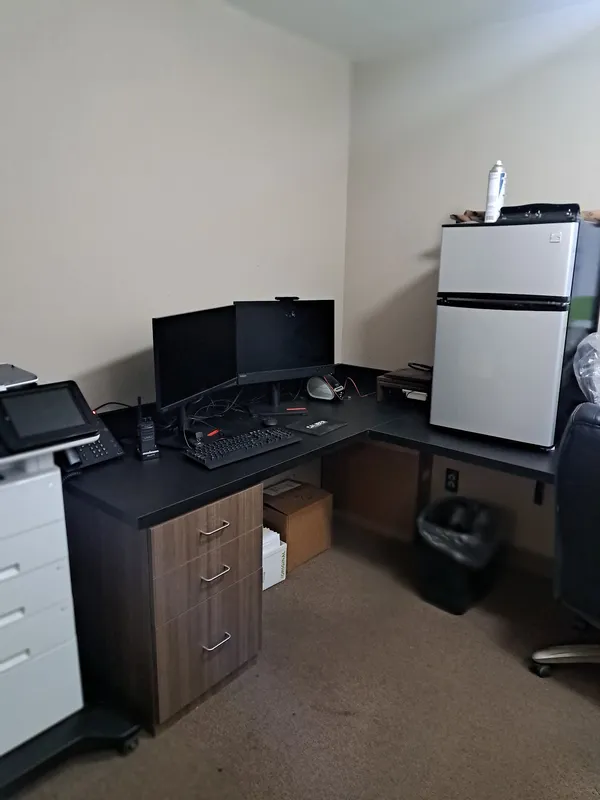 Office with a desk, dual monitors and a mini refrigerator