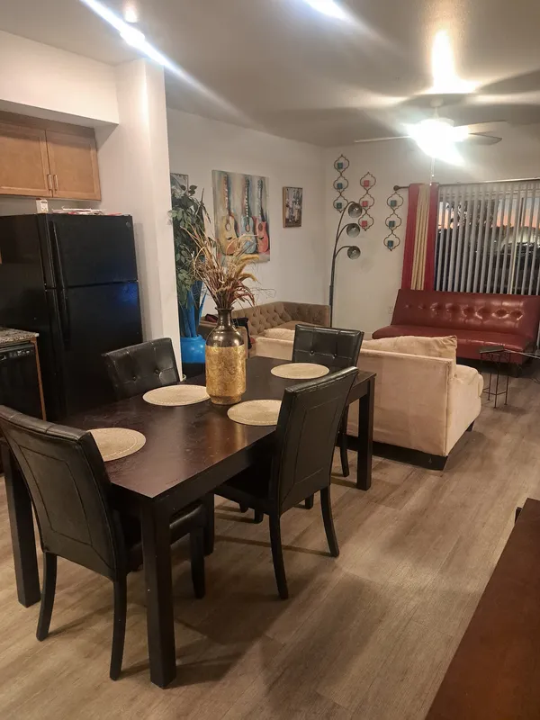 Open dining and living area with a dark wood table set for four