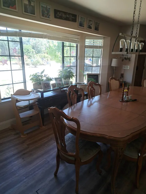 Dining room with a long wood table beside large windows