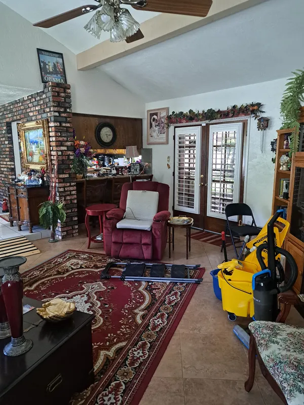 Living room with a yellow mop bucket during a cleaning job