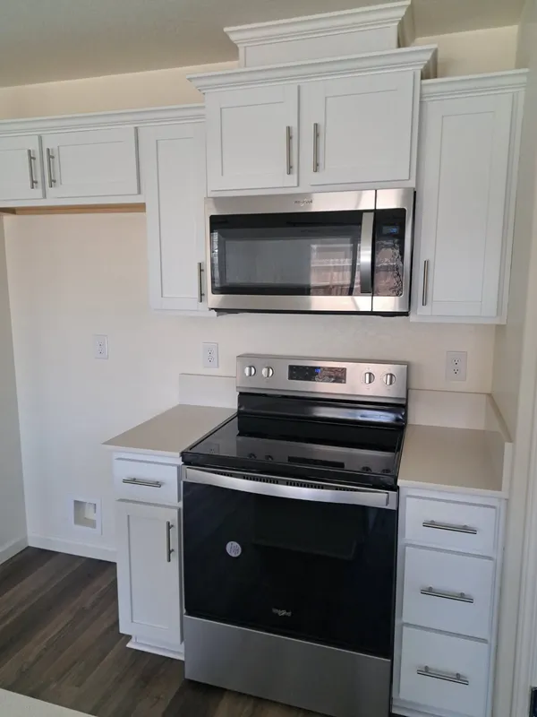 White kitchen with stainless microwave and range